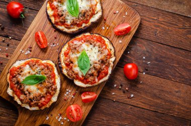 Domates soslu patlıcanlı pizza, kıymalı kıyma, Mozzarella ve Basil, kırsal arka planda mini pizza.