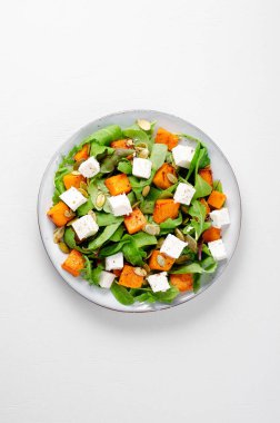 Arugula, Feta peyniri ve balkabağı tohumlu balkabağı salatası, kavrulmuş balkabağı salatası, Parlak arka planda sonbahar salatası