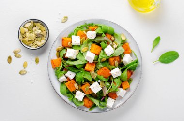 Arugula, Feta peyniri ve balkabağı tohumlu balkabağı salatası, kavrulmuş balkabağı salatası, Parlak arka planda sonbahar salatası