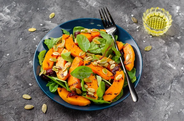Grilled Pumpkin Salad with Arugula, Spinach, and Pumpkin Seeds, Salad Mix with Roasted Pumpkin, Autumn Salad on Dark Background