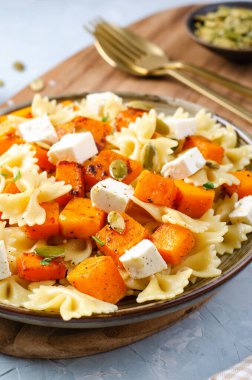 Kavrulmuş balkabaklı makarna, Kabaklı Farfalle Makarnası ve Parlak Arkaplanda Feta Peyniri