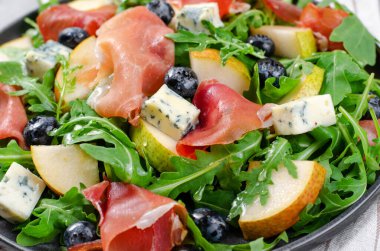 Armut, Arugula, Jamon, Mavi Peynir ve Yabanmersinli Salata, Parlak Arkaplanda Lezzetli Taze Salata Aperatifi