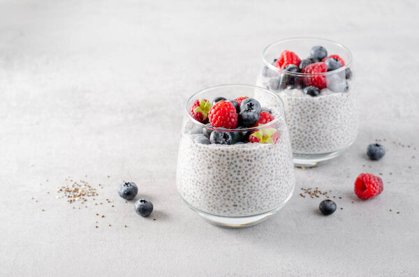 Healthy Chia Pudding in a Glass with Fresh Berries on Bright Background