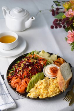 Somonla Sağlıklı Kahvaltı, Yağda Yumurta, Avokado, Sebze Salatası ve Parlak Arkaplanda Toppings