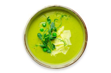 Yeşil sebzeli bezelye çorbası, brokoli ve beyaz arka planda peynirli bezelye filizi.
