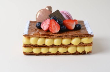 Vanilya kremalı ve parlak arkaplanda taze böğürtlenli geleneksel Fransız tatlı millefeuille.