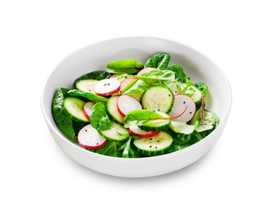 Turplu taze salata, salatalık ve beyaz arka planda marul, sağlıklı vejetaryen yemeği.