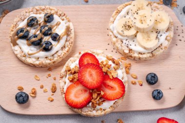 Pirinçli krakerler, muzlu krakerler, taze meyveler, yoğurt ve granola, sağlıklı yiyecekler, kahvaltı fikri...