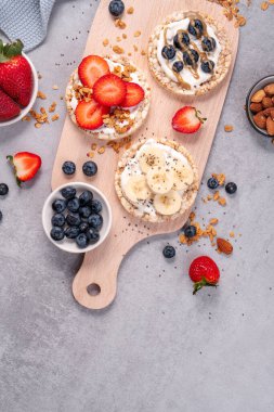 Pirinçli krakerler, muzlu krakerler, taze meyveler, yoğurt ve granola, sağlıklı yiyecekler, kahvaltı fikri...