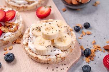 Pirinçli krakerler, muzlu krakerler, taze meyveler, yoğurt ve granola, sağlıklı yiyecekler, kahvaltı fikri...