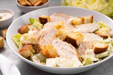 Parmesan peynirli, marullu, soslu ve kızarmış tavuk salatası.