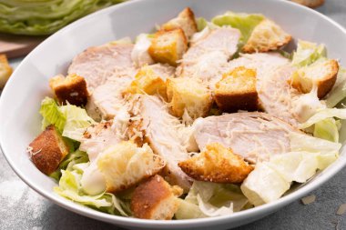 Parmesan peynirli, marullu, soslu ve kızarmış tavuk salatası.