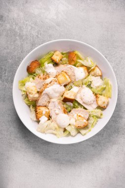 Parmesan peynirli, marullu, soslu ve kızarmış tavuk salatası.