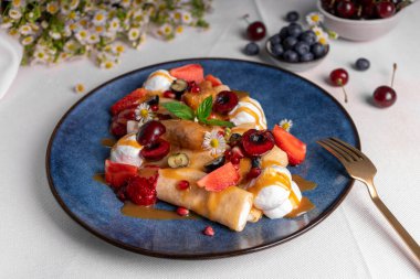 Yaz meyveleri ve soslu leziz krepler, süzme peynirli rulo krepler tabakta dolma