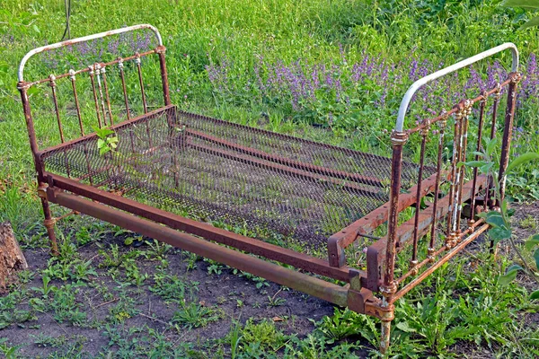 Old iron bed on a green meadow. Kharkov, Ukraine