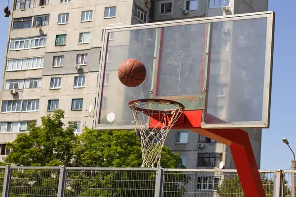 ハルコフのストリートスポーツグラウンドのリングに飛行中のバスケットボールボール — ストック写真