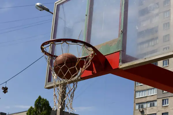 ハルコフのストリートスポーツグラウンドのリングに飛行中のバスケットボールボール — ストック写真