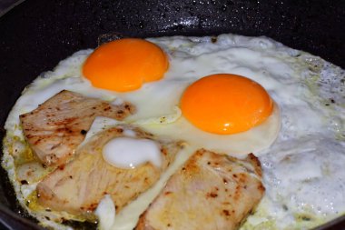 Kızarmış yumurta ve domuz eti tavada kızartılır.
