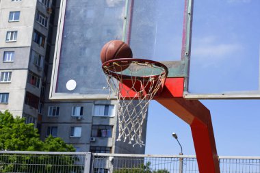Basketbol topu bir sokak sporları sahasında sepetin içine uçuyor.