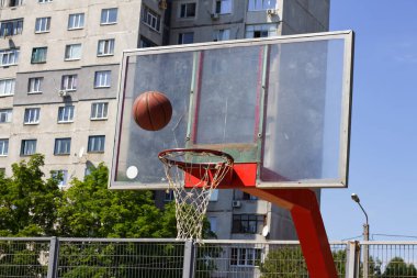 Basketbol topu bir sokak sporları sahasında sepetin içine uçuyor.