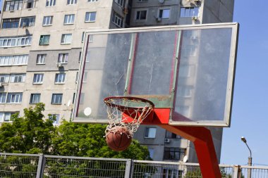 Basketbol topu bir sokak sporları sahasında sepetin içine uçuyor.