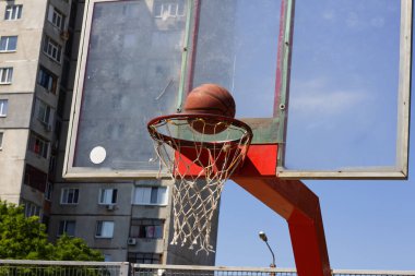 Basketbol topu bir sokak sporları sahasında sepetin içine uçuyor.