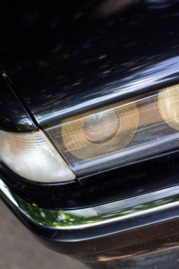 Siyah bir arabanın önünde. Eski bir Avrupa arabasının farları.