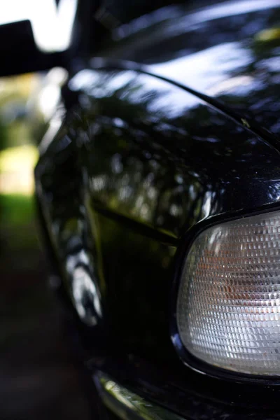 Egy Fekete Autó Előtt Egy Régi Európai Autó Fényszórói — Stock Fotó