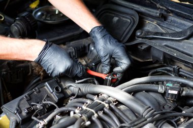 Eski bir Avrupa arabasının motorunu tamir eden usta elleri.