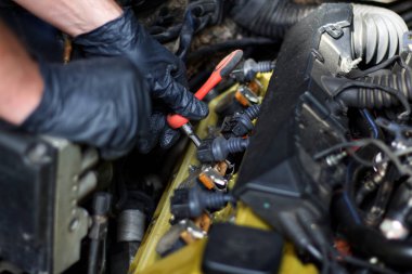 Eski bir Avrupa arabasının motorunu tamir eden usta elleri.