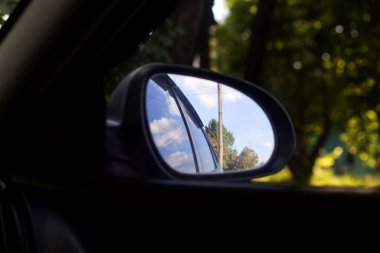 Yolcu bölümünden arabanın yan aynasına bak.