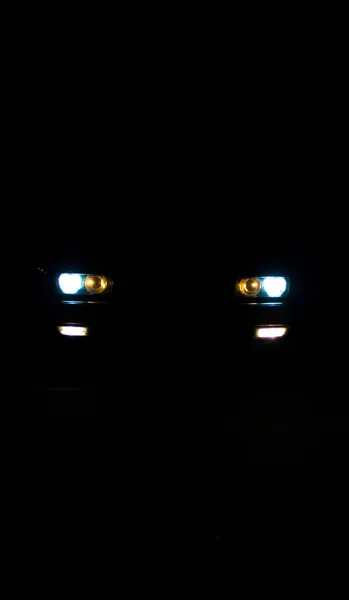 欧洲汽车的前灯在黑暗中闪烁着光芒 — 图库照片