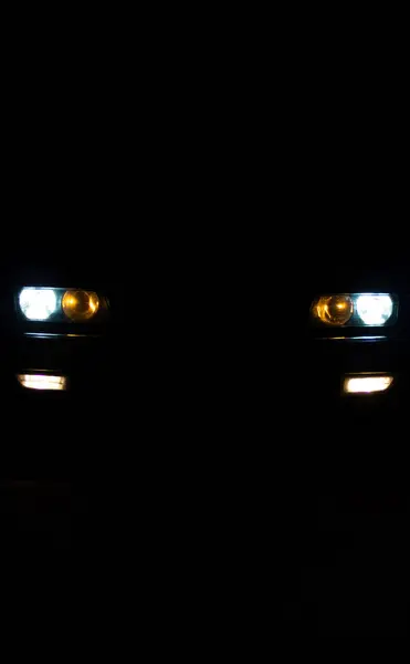 欧洲汽车的前灯在黑暗中闪烁着光芒 — 图库照片