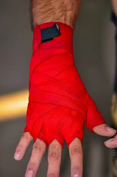Boxer\'s hand wrapped in red bandage