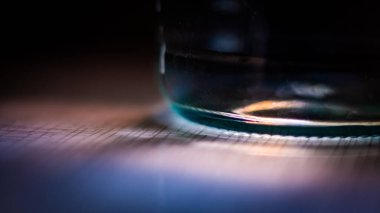 Gün batımında güzelce aydınlanan cam su şişesi.