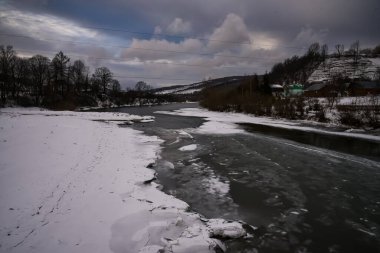 Ukrayna Karpatlarında yarı donmuş bir dağ nehri..