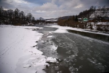 Ukrayna Karpatlarında yarı donmuş bir dağ nehri..