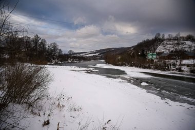 Ukrayna Karpatlarında yarı donmuş bir dağ nehri..