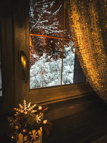 Winter view from the window. Snow on the window. New Year\'s decorations on the window.