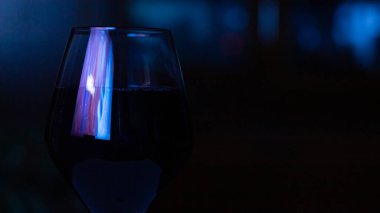 Romantik ve karanlık bir odada bir kadeh kırmızı şarap.