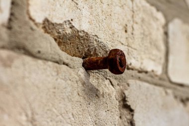 Eski paslı bir cıvata ve tuğla bir duvara yapışmış fındık