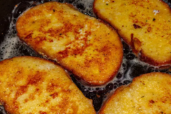 stock image Fry bread croutons in egg in a frying pan