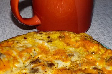 Kahvaltıda omletle birlikte bir fincan kahve. Et ve peynirli omlet.