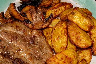 Mantarlı biftek ve ızgarada pişirilmiş patates.