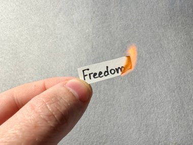 Yanan bir kağıt parçasında özgürlük kelimesi