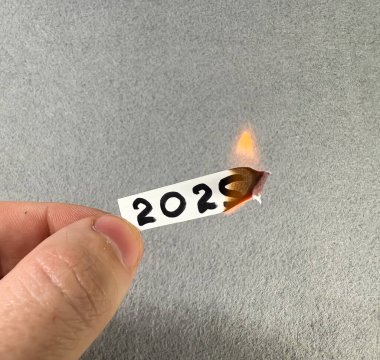2025 rakamları yanan bir kağıt parçasında