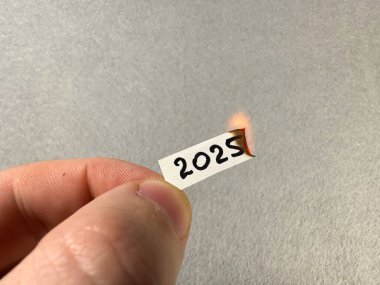 2025 rakamları yanan bir kağıt parçasında