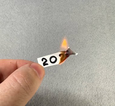 2025 rakamları yanan bir kağıt parçasında