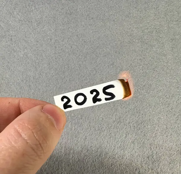 2025 rakamları yanan bir kağıt parçasında