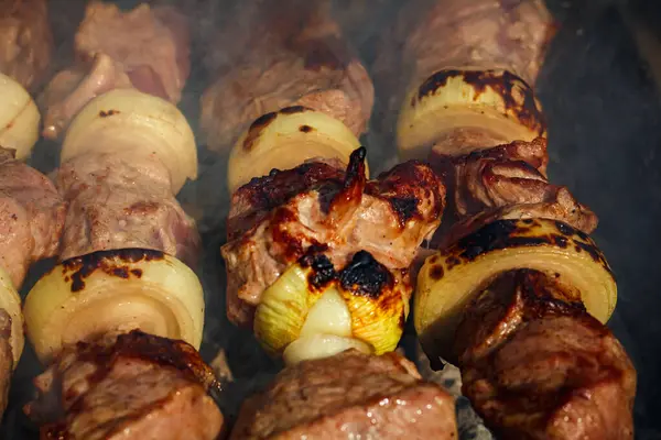 Izgarada sulu domuz şiş. Barbekü 'nün yaz aroması. Duman ve soğanlı Shashlik..